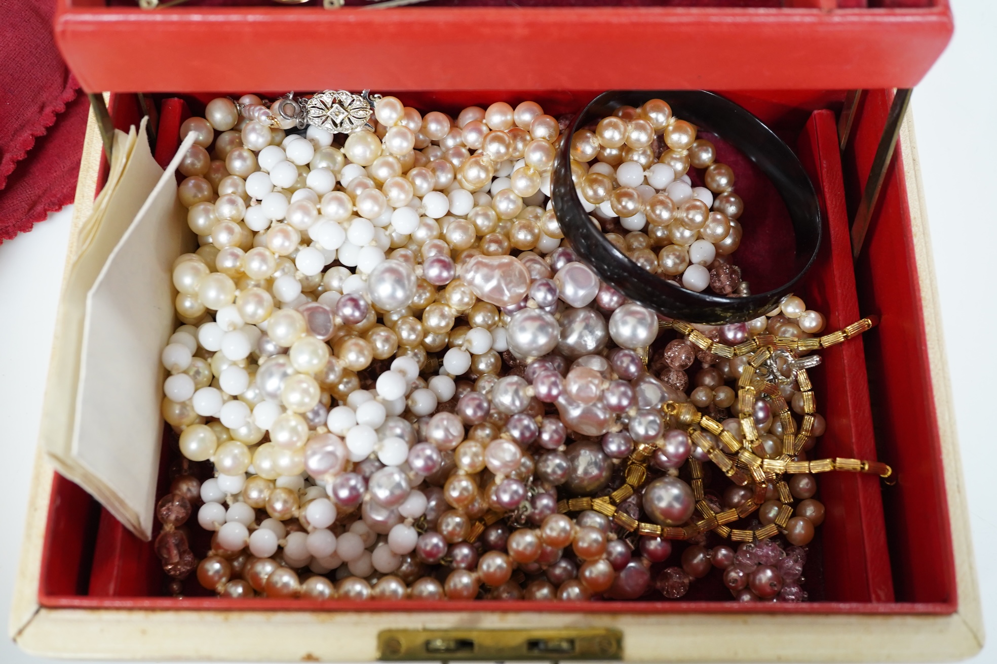 A lady's Retro gold watch by DelBana, 1940s, the square dial in a rose gold case accented with rubies, stamped 14K, to a black cord strap; together with a collection of assorted costume jewels, in a two-tiered white leat